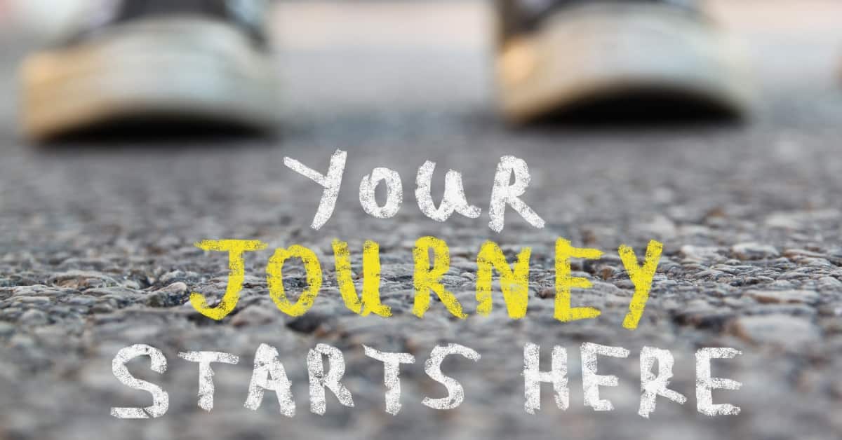 Image with selective focus over asphalt road and person with handwritten text - your journey starts here. education and motivation concept.
