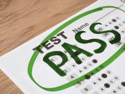 MBE multiple-choice test answer sheet with the word 'PASS' written in bold green letters and circled, indicating a successful test result.