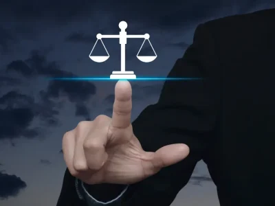 Law student in a suit pointing at a digital justice scale icon, symbolizing legal technology innovation and modern bar exam preparation with Themis Bar Review.