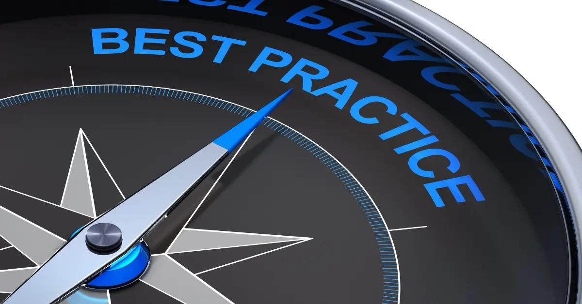 A close-up of a modern metallic compass face with a sleek silver and blue needle pointing toward the words “BEST PRACTICE.”